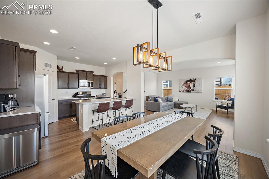 Image 17 of 45: Open-concept interior featuring wood-finish flooring, recessed lighting, an