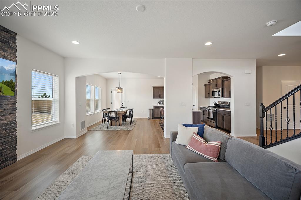 Image 19 of 45: Open-concept living area featuring wood-finish flooring, recessed lighting,