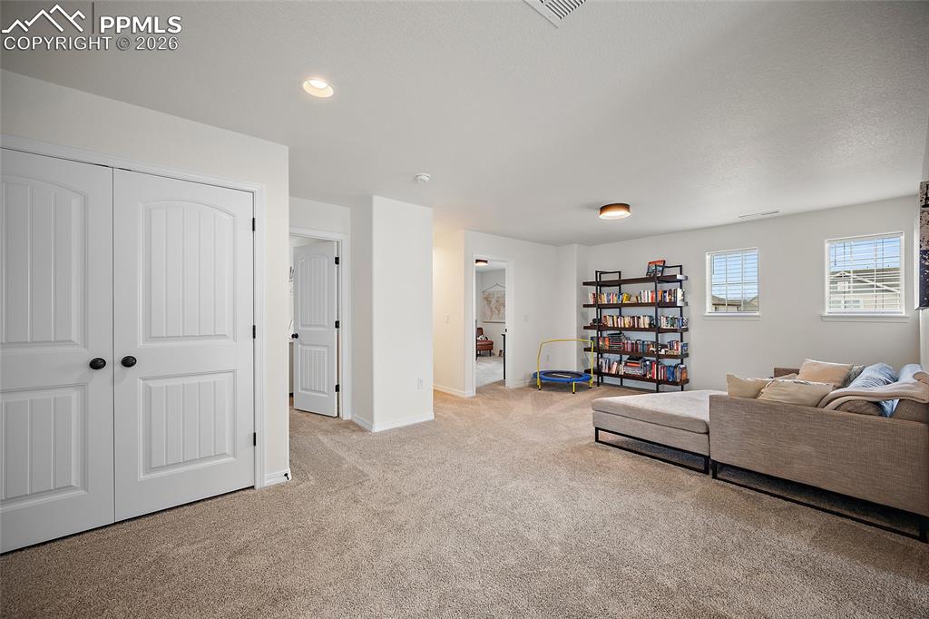 Image 20 of 45: Spacious carpeted room featuring white walls, two double-panel white doors 