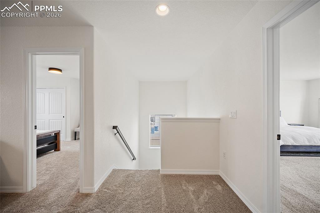 Image 23 of 45: Carpeted landing with white walls and trim, featuring a recessed ceiling li