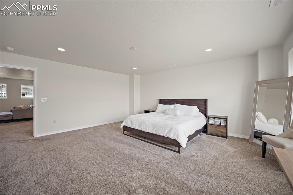 Image 25 of 45: Spacious room with plush carpeting, recessed lighting, and crisp white wall