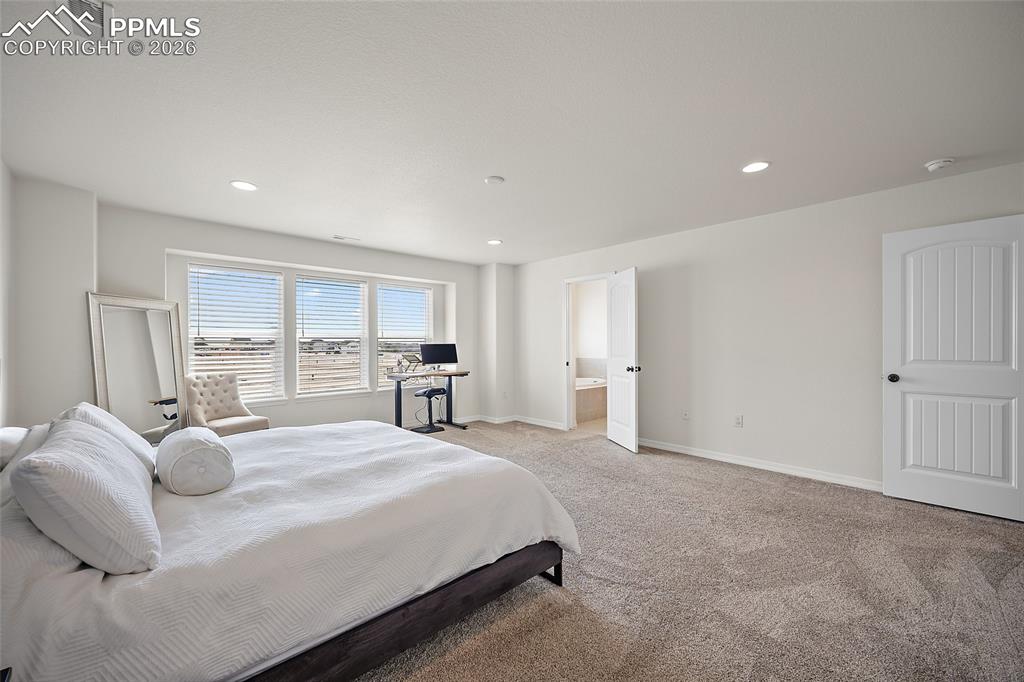 Image 26 of 45: Spacious room featuring multiple windows with horizontal blinds, neutral ca