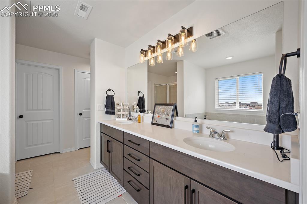 Image 27 of 45: Double vanity with a light countertop, multiple storage drawers, and under-