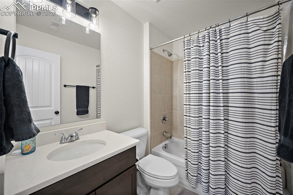 Image 34 of 45: Bathroom featuring a dark wood-finish vanity with a light countertop, an un