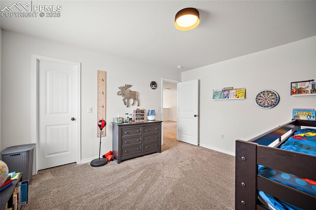 Image 36 of 45: Light-colored walls and plush carpet flooring complement a flush-mount ceil