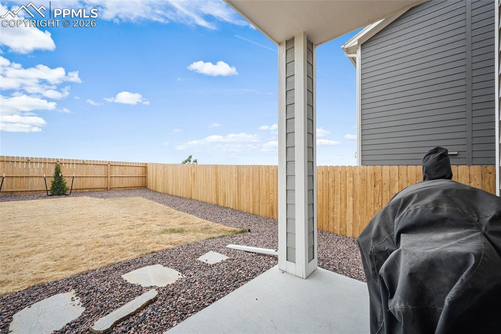 Image 39 of 45: Covered patio with concrete flooring