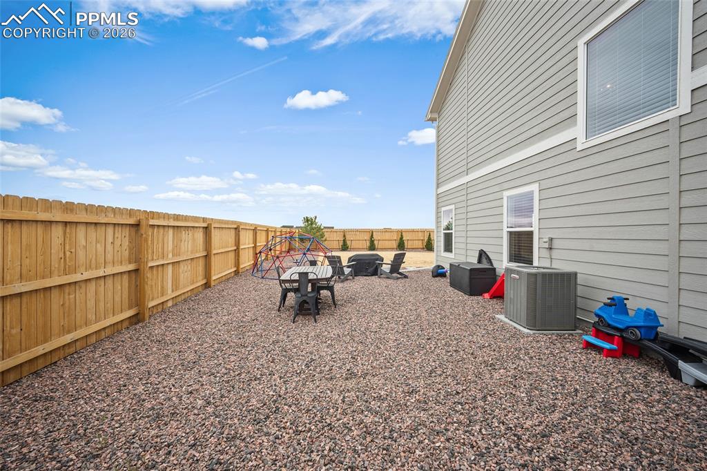 Image 42 of 45: Spacious outdoor area with a wood privacy fence, gravel landscaping, and gr