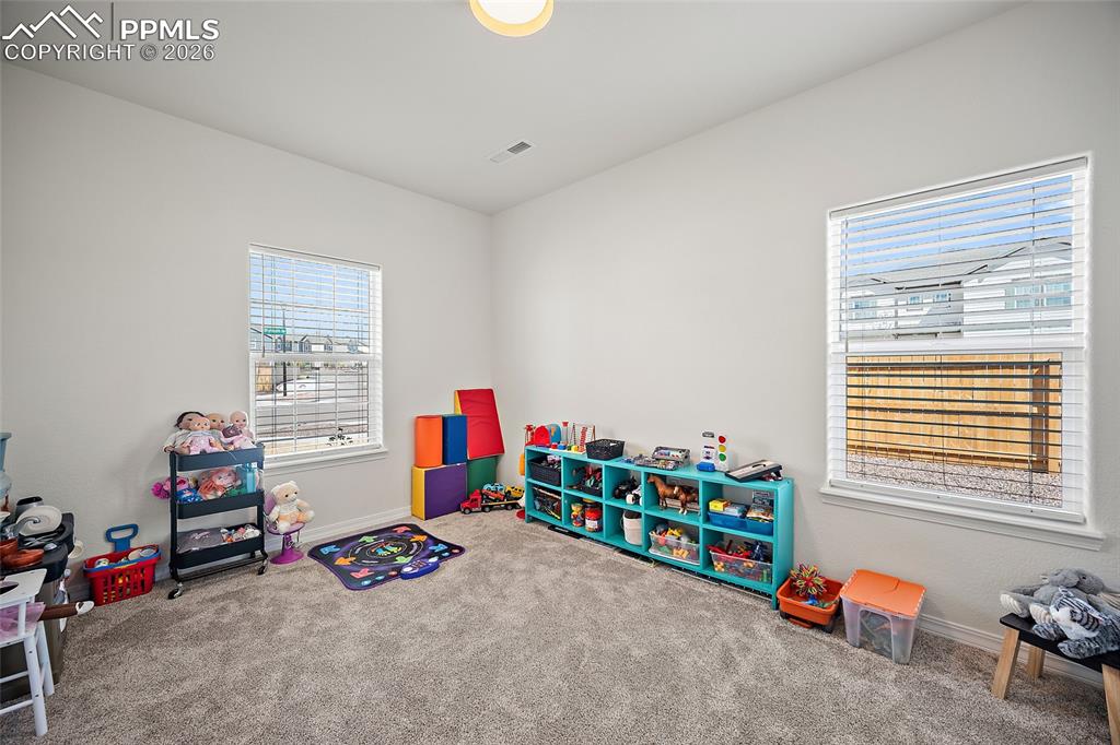 Image 6 of 45: Carpeted room featuring two windows with horizontal blinds, neutral wall pa