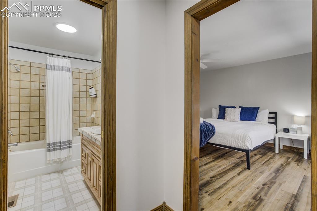 Image 16 of 50: Ensuite bathroom featuring shower/bath combination with shower curtain and 