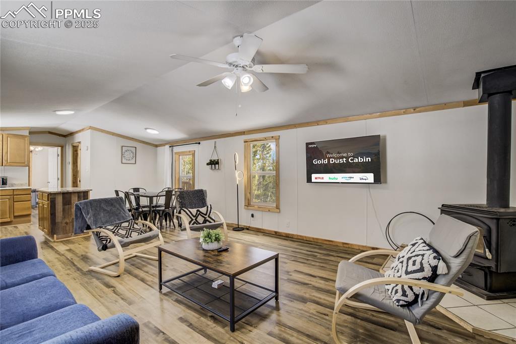 Image 32 of 50: 2nd home open to the living room, dining room and kitchen. Wood stove, vaul