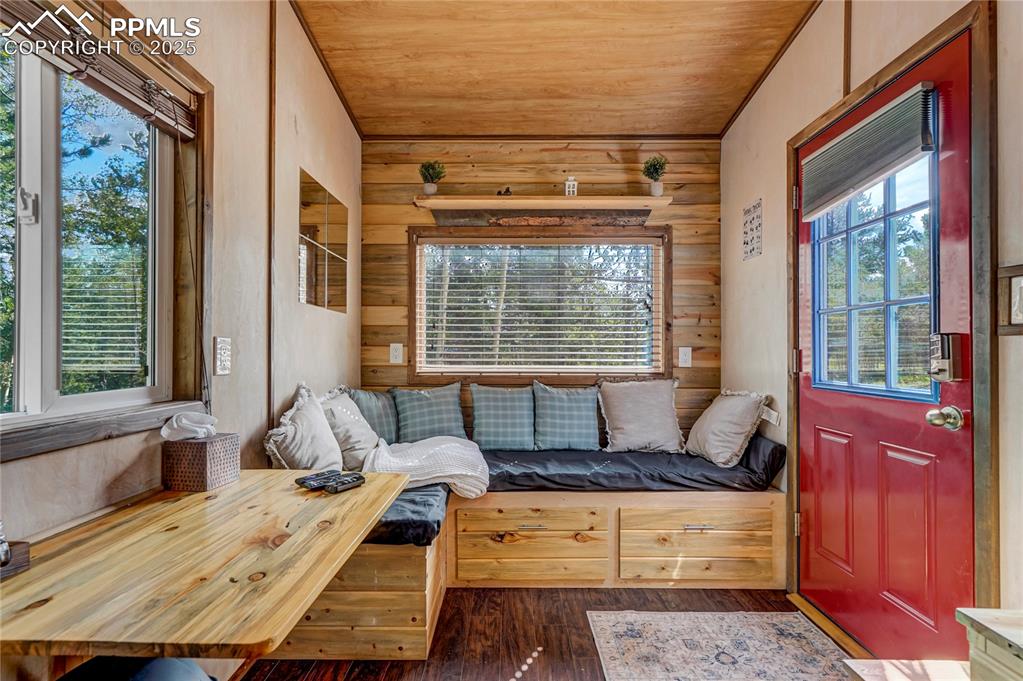 Image 44 of 50: Tiny home - dining and sitting area. Storage under the couch/bed.  Full win
