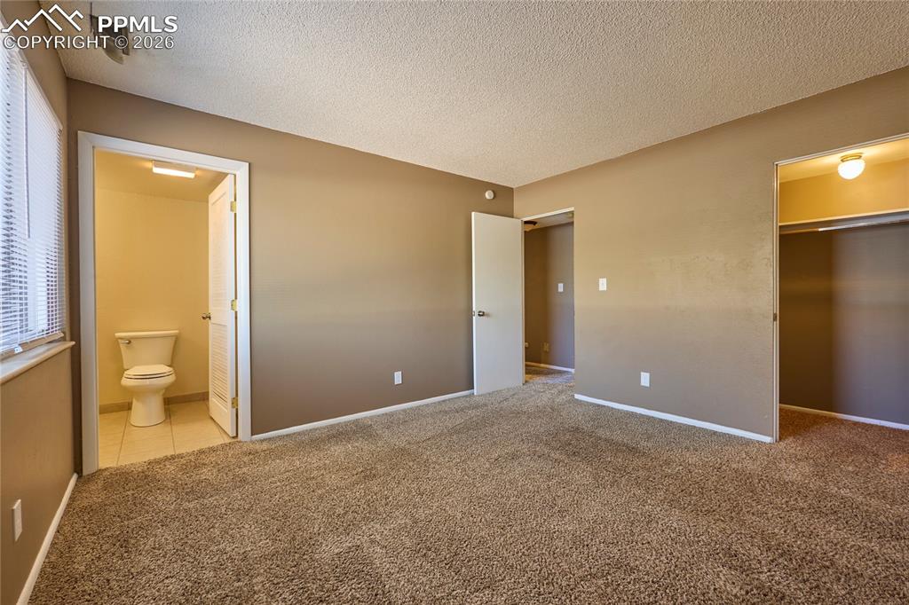 Image 16 of 28: Master bedroom featuring a walk-in spacious closet, carpet and attached 1/2
