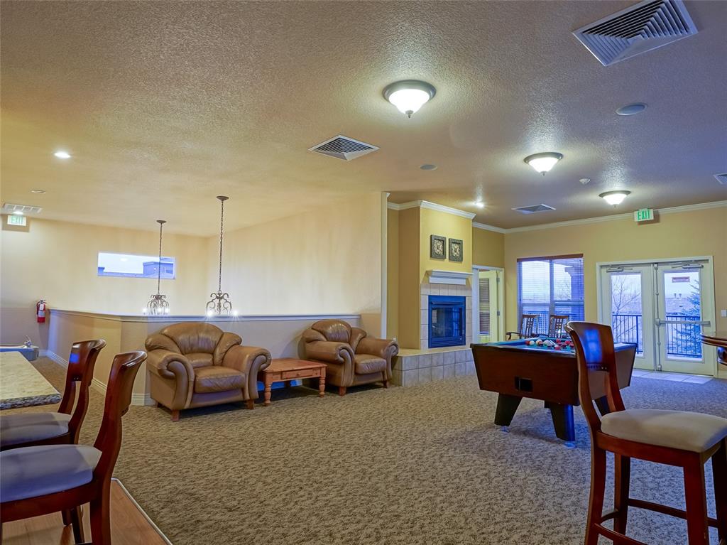 Image 26 of 31: Community Game room and Kitchen with a tile fireplace View 2