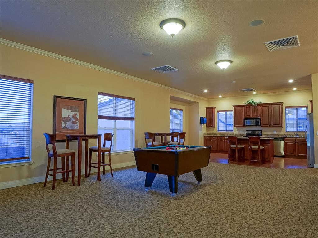 Image 27 of 31: Community Game room and Kitchen with a tile fireplace View 2