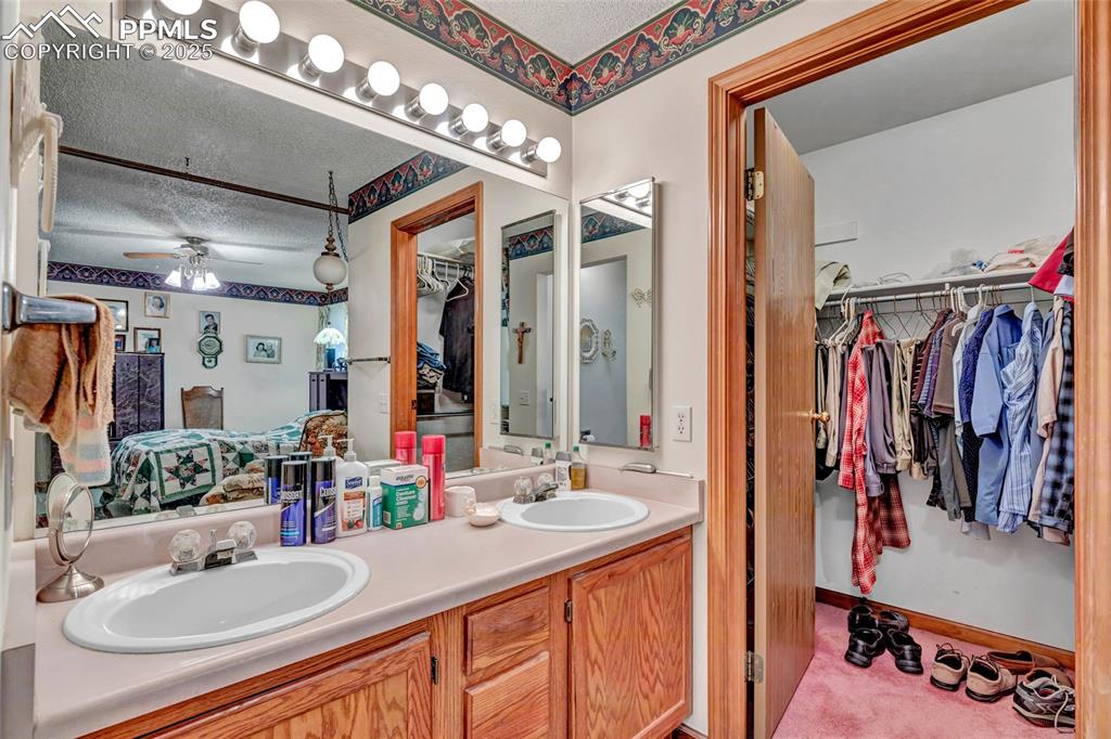 Image 13 of 21: Convenient ensuite setup with dual vanities and a walk-in closet right wher