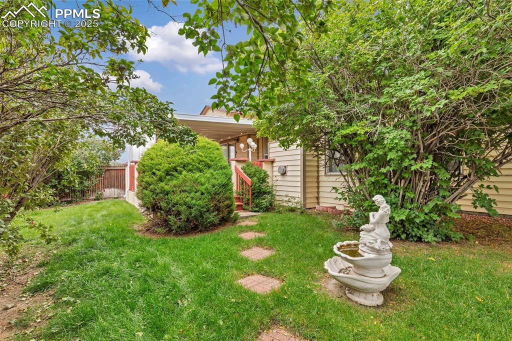 Image 19 of 21: Private, green, and full of charm! Enjoy a peaceful yard surrounded by matu