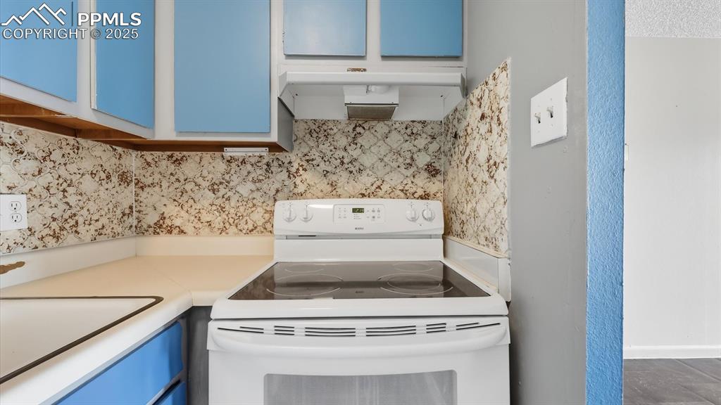 Image 14 of 31: Smooth top range oven and vent hood.