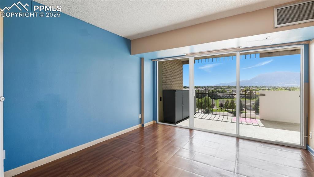 Image 22 of 31: Primary Bedroom with linoleum floor, walk in closet, and slider to the outd