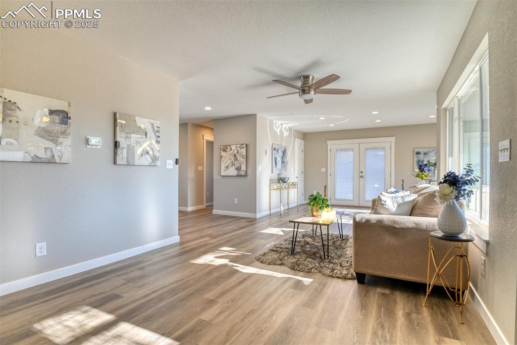 Image 15 of 48: Living area featuring a ceiling fan, wood finished floors, french doors, an