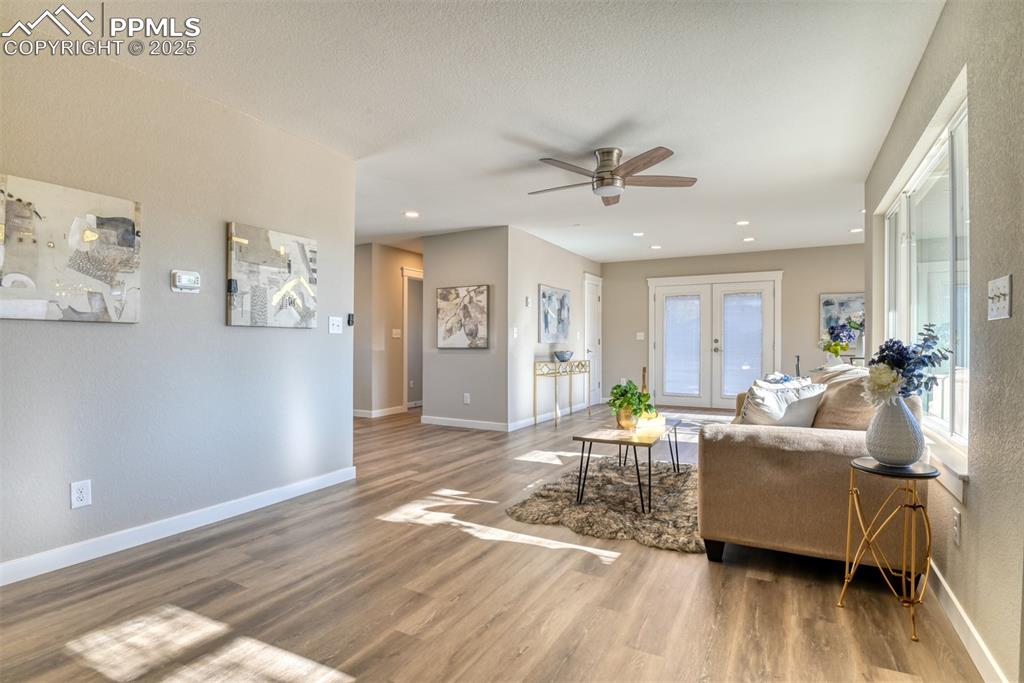 Image 16 of 48: Living area featuring wood finished floors, ceiling fan, french doors, and 