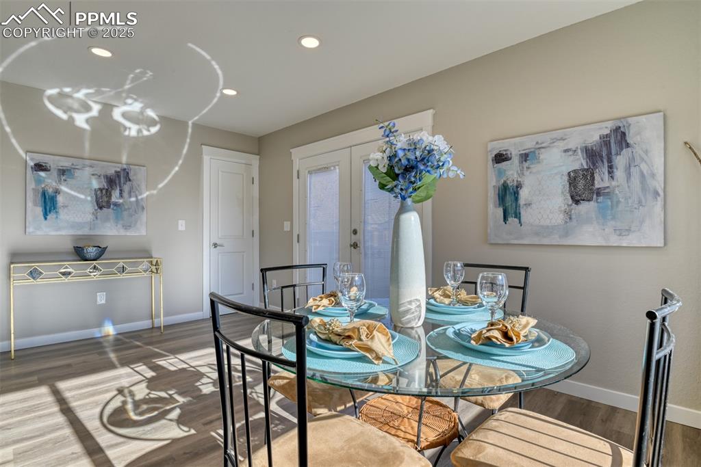 Image 20 of 48: Dining area with french doors, wood finished floors, and recessed lighting