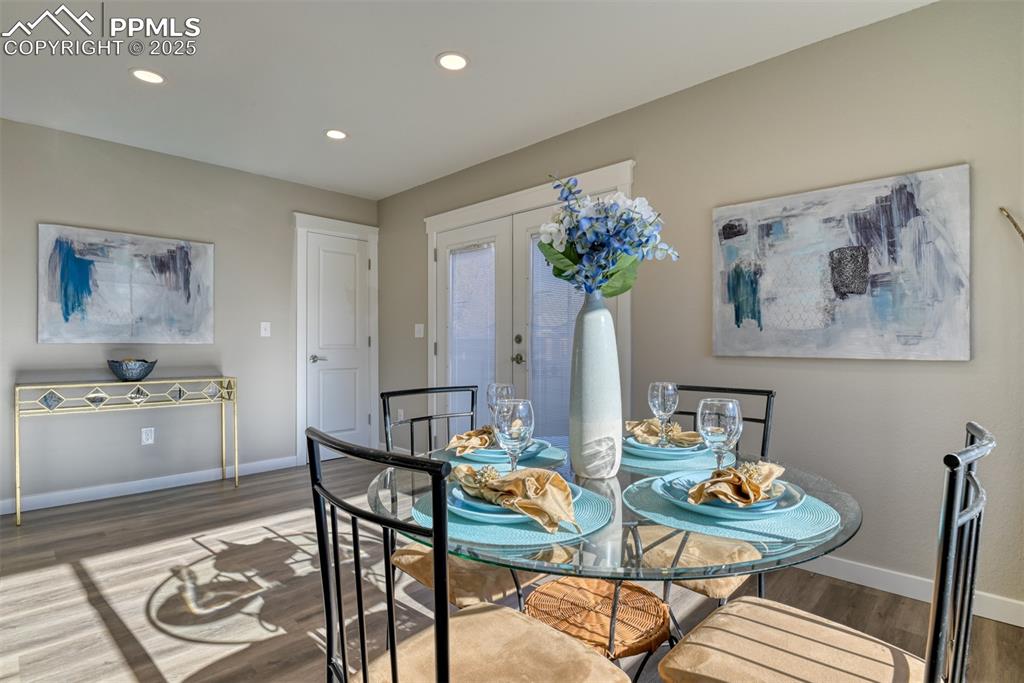 Image 21 of 48: Dining space with french doors, wood finished floors, and recessed lighting