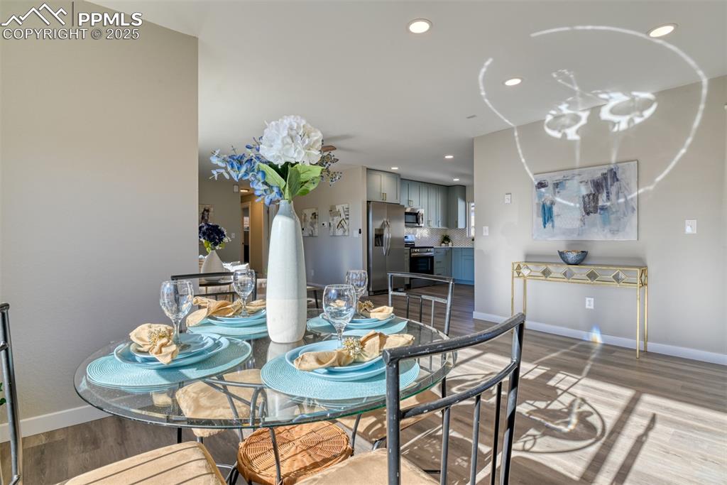 Image 22 of 48: Dining space with dark wood-style flooring and recessed lighting