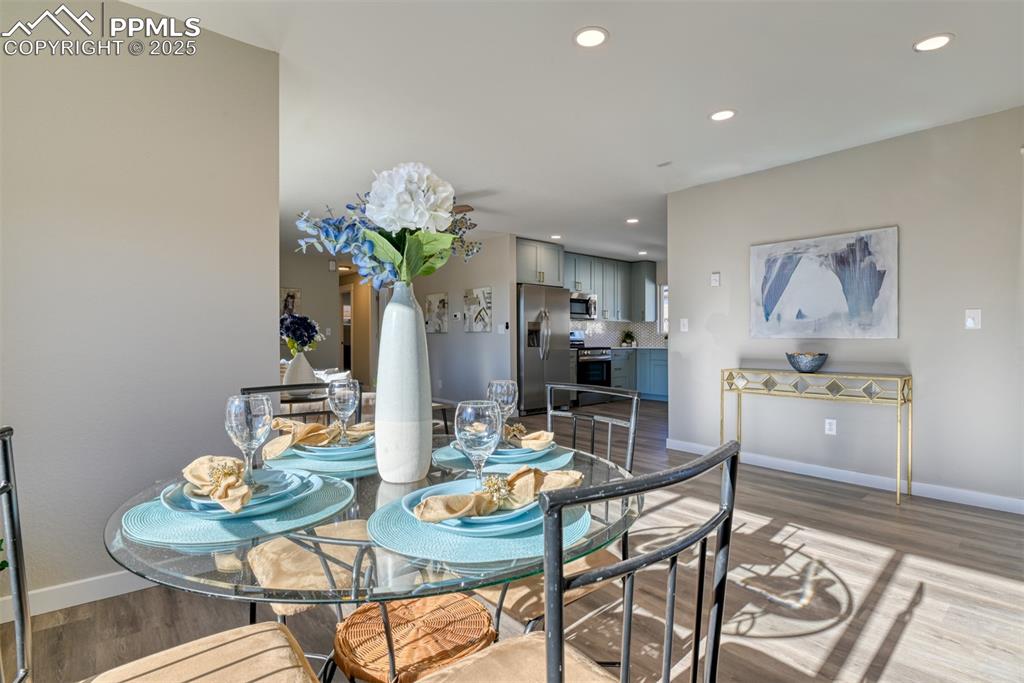 Image 23 of 48: Dining room with dark wood finished floors and recessed lighting