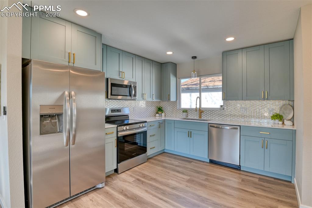 Image 26 of 48: Kitchen with appliances with stainless steel finishes, light wood finished 