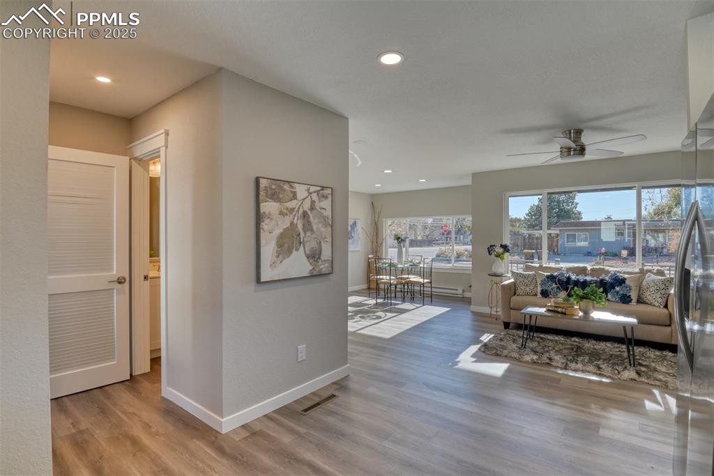Image 28 of 48: Living room with light wood-style floors, recessed lighting, and ceiling fa