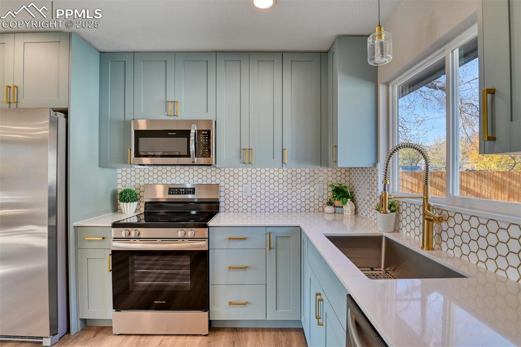 Image 29 of 48: Kitchen featuring stainless steel appliances, decorative backsplash, light 