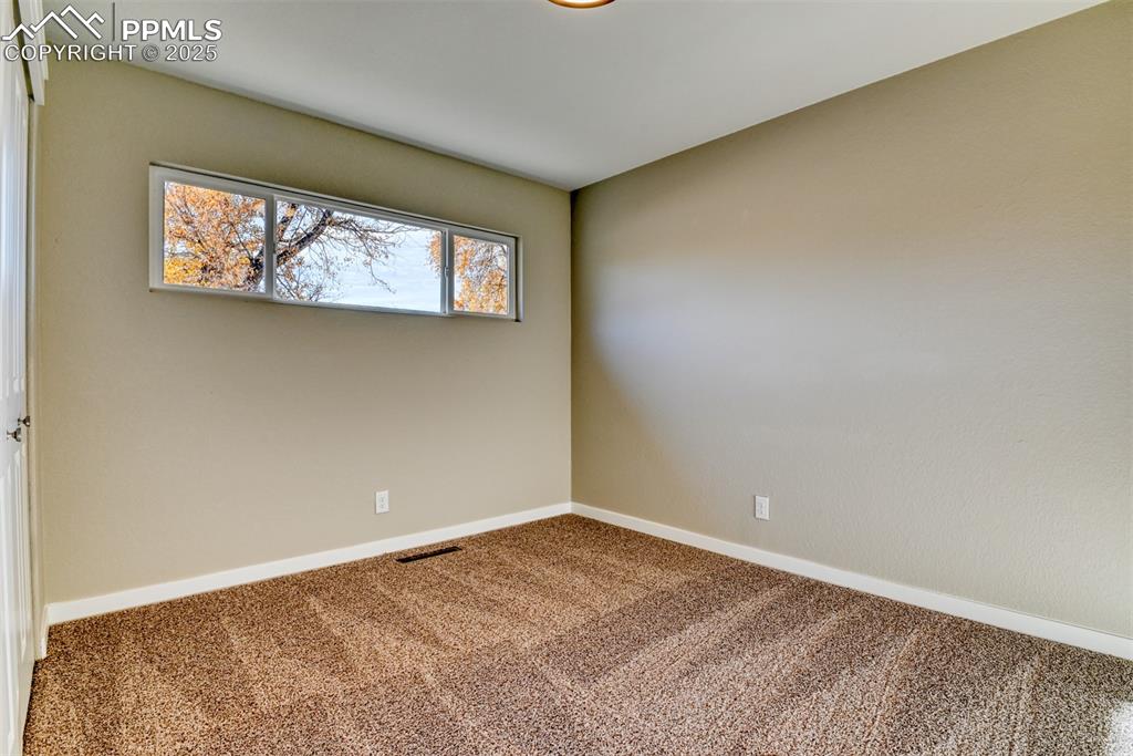 Image 38 of 48: Carpeted empty room featuring baseboards