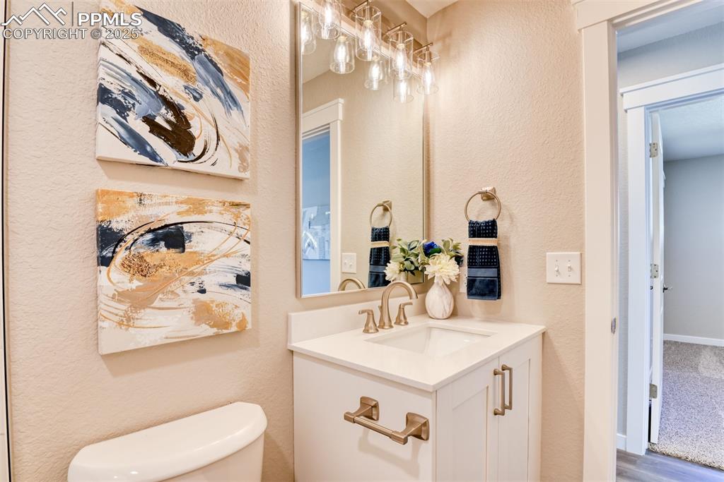 Image 43 of 48: Bathroom with a textured wall and vanity