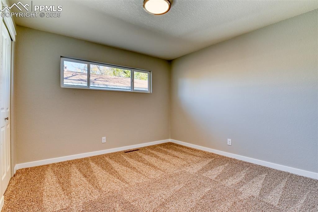 Image 44 of 48: Carpeted empty room with baseboards and a textured ceiling