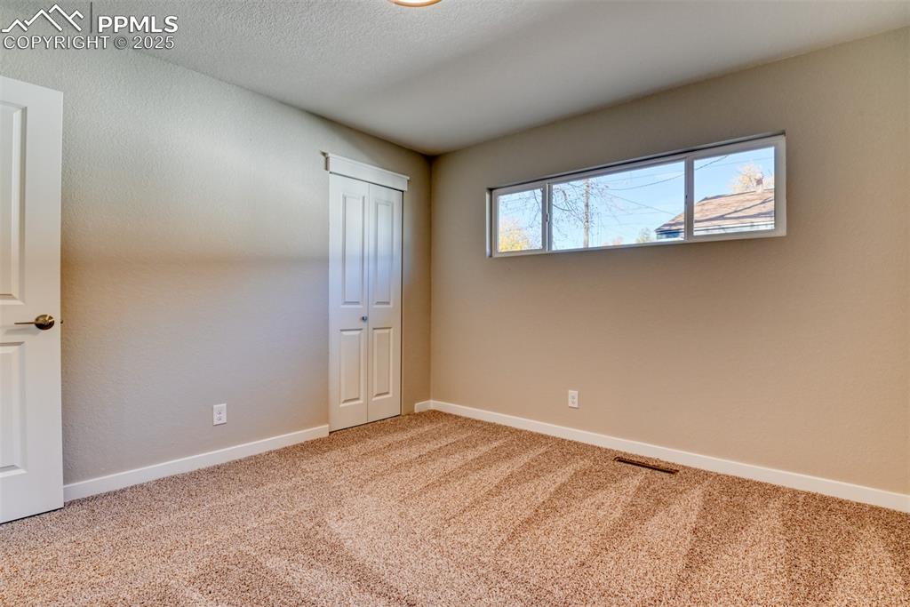 Image 45 of 48: Unfurnished bedroom featuring light colored carpet, a closet, and a texture