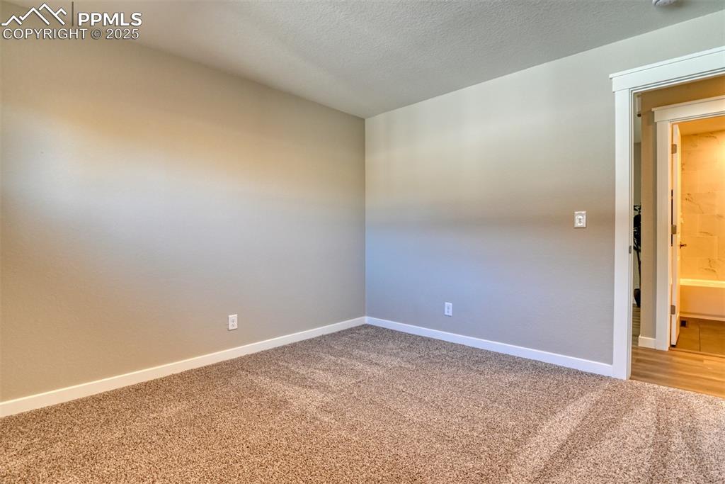 Image 47 of 48: Empty room featuring light carpet and a textured ceiling