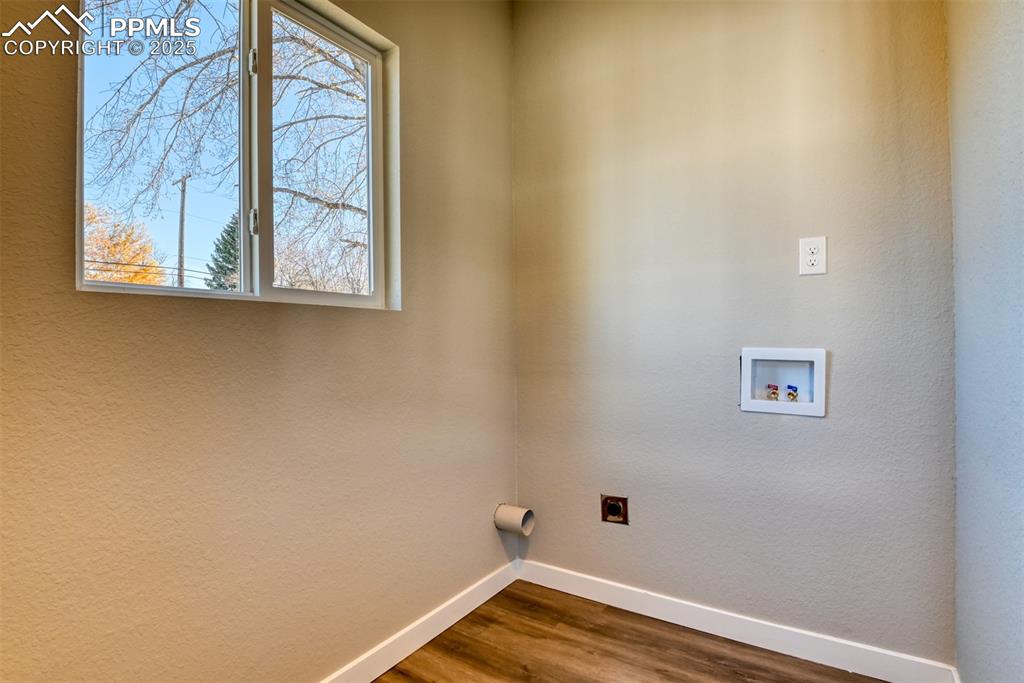 Image 48 of 48: Washroom with dark wood-style flooring, electric dryer hookup, hookup for a