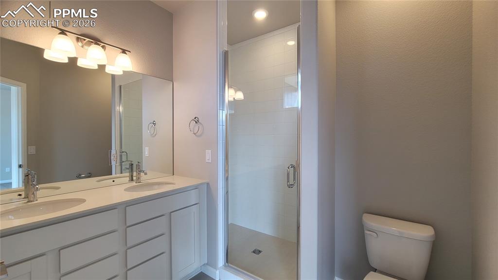 Image 19 of 26: Primary Bathroom with quartz countertop, double vanity, and shower with til