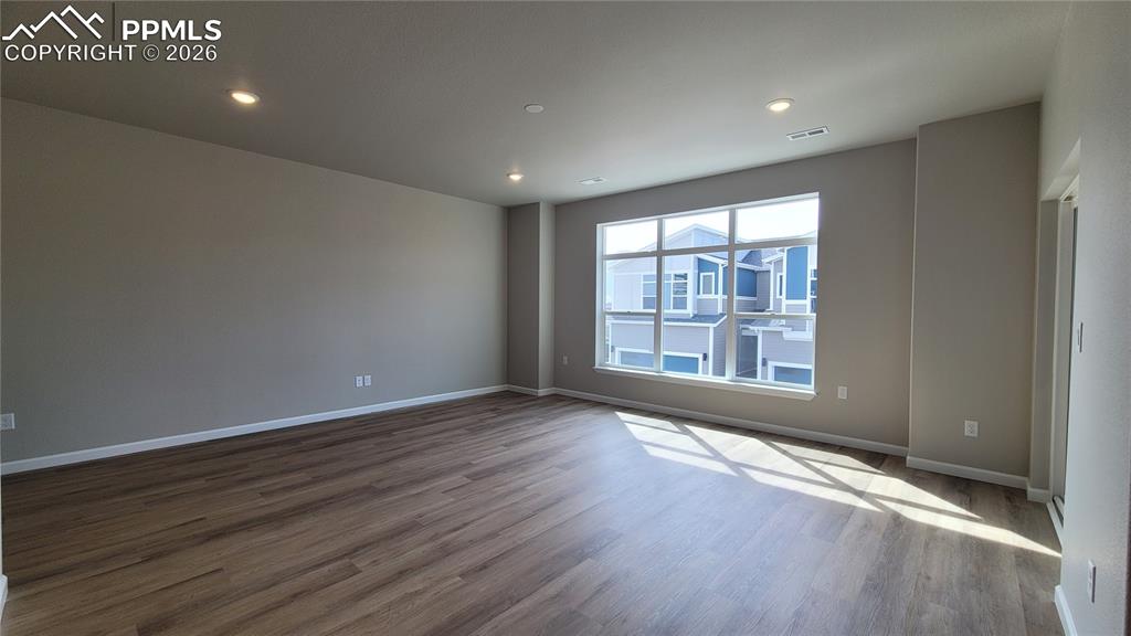 Image 7 of 26: Living Room in LVP flooring, LED lighting, walk out to deck, and an abundan