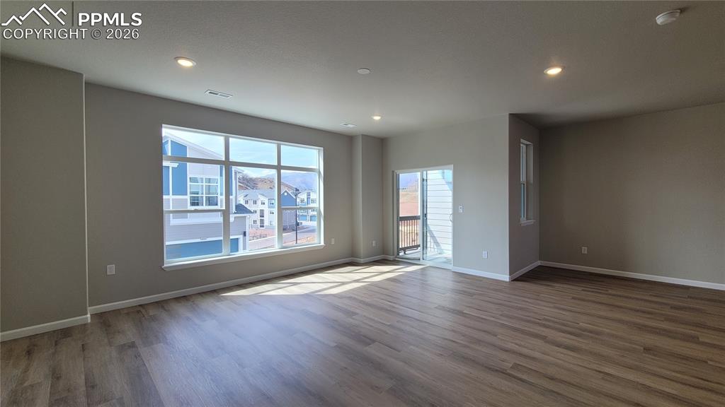 Image 8 of 26: Living Room in LVP flooring, LED lighting, walk out to deck, and an abundan