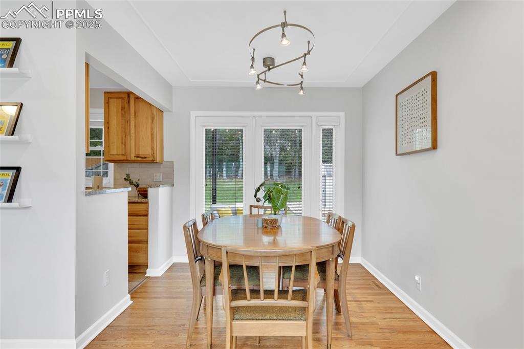 Image 12 of 50: Dining room with light wood-style flooring and a chandelier