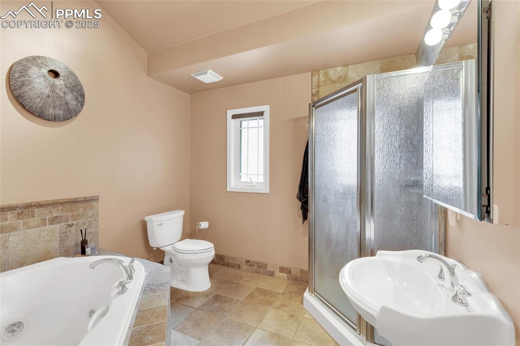 Image 19 of 50: Full bath with a tub with jets and a stall shower