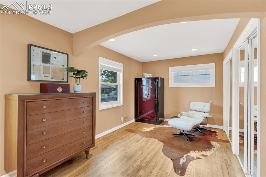 Image 22 of 50: Sitting room with arched walkways, light wood finished floors, and recessed