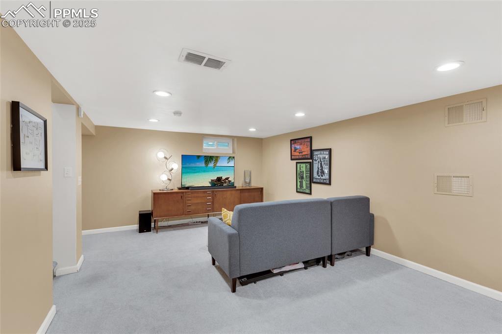Image 25 of 50: Living room with light carpet and recessed lighting