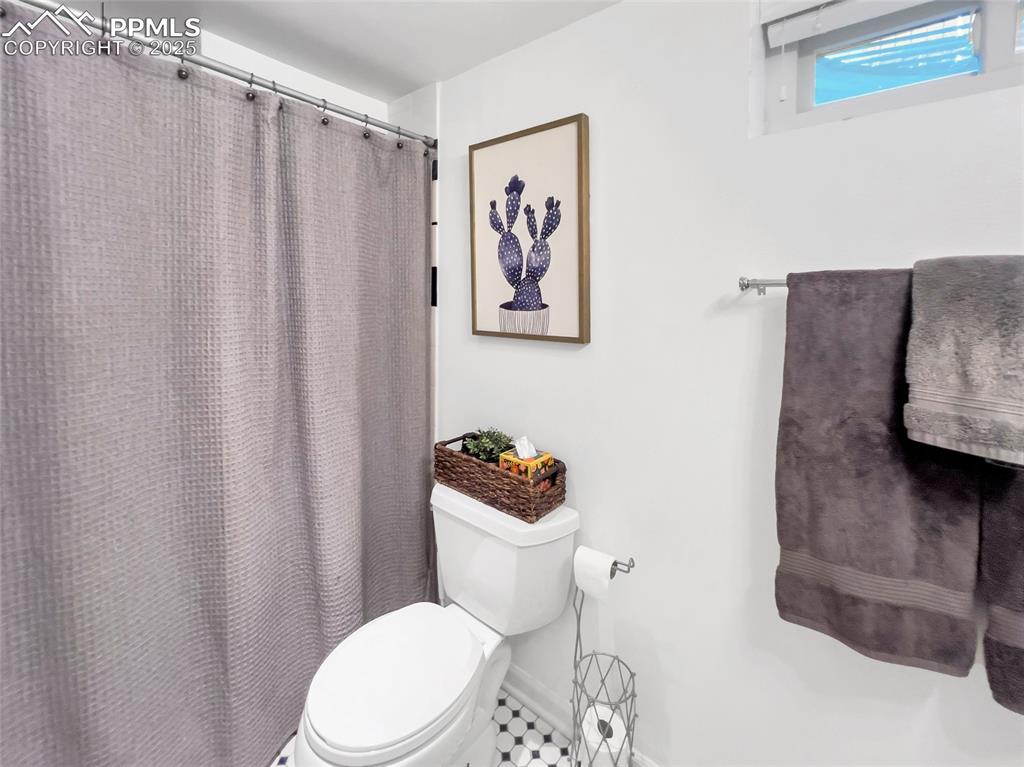 Image 38 of 50: Full bath with toilet and a shower with shower curtain