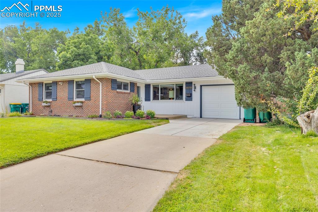 Image 4 of 50: Single story home with an attached garage, a front yard, driveway, brick si