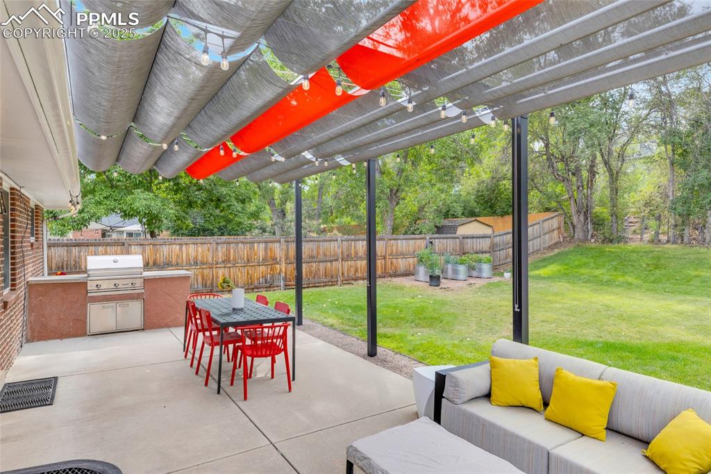 Image 40 of 50: Fenced backyard with a pergola, a patio, an outdoor living space, area for 