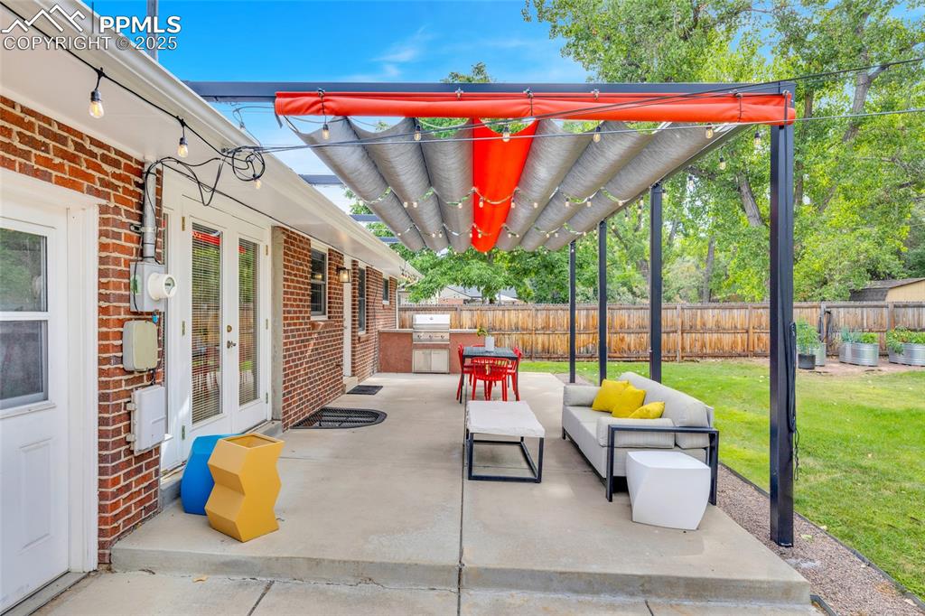 Image 41 of 50: View of patio with an outdoor kitchen and an outdoor living space