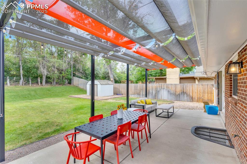 Image 43 of 50: Fenced backyard featuring a pergola, a storage shed, a patio area, and outd