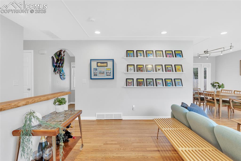 Image 7 of 50: Living area featuring wood finished floors, recessed lighting, and arched w